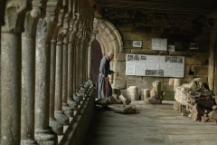Un moine passe sous la galerie ouest de l'abbaye