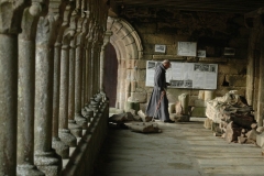 Un moine passe sous la galerie ouest de l'abbaye