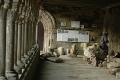 Un moine passe sous la galerie ouest de l'abbaye