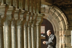 Un moine passe sous la galerie ouest de l'abbaye