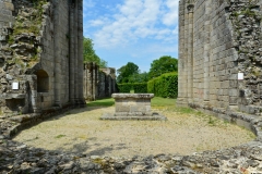 Hotel de l'église abbatiale, surplombé par les absidioles. En arrière-plan, le mur de la galerie nord