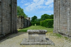 Hotel de l'église abbatiale, surplombé par les absidioles. En arrière-plan, le mur de la galerie nord