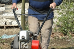 Un des moines passe le motoculteur dans le jardin de l'abbaye