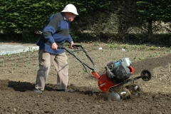 Un des moines passe le motoculteur dans le jardin de l'abbaye.