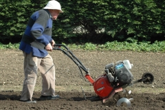 Un des moines passe le motoculteur dans le jardin de l'abbaye.