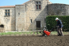 Un des moines passe le motoculteur dans le jardin de l'abbaye.