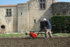 Un des moines passe le motoculteur dans le jardin de l'abbaye.